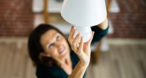 woman changing a light bulb