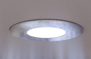 A close up of an LED downlight brightening up a living room.